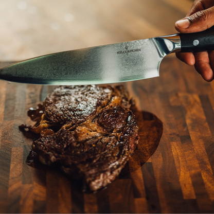 Hells Kitchen knife on a cutting board with a piece of meat